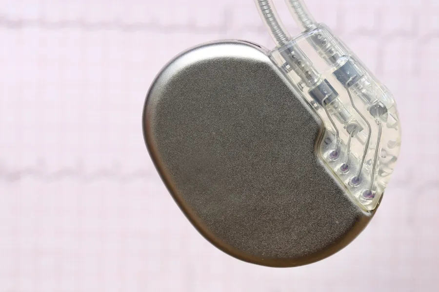 Liten, rund og flat boks med to tynne ledninger