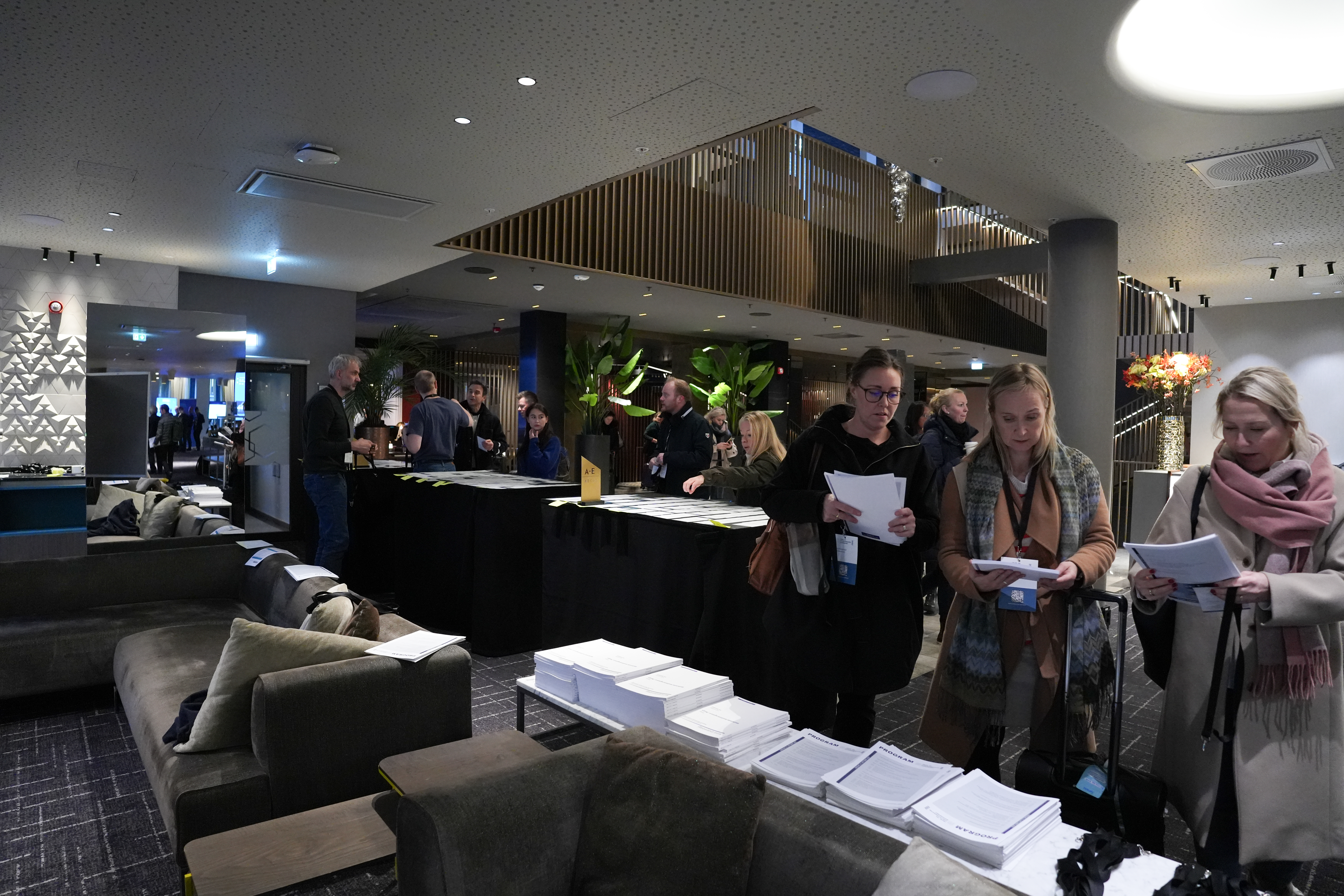 Personer som står foran programmer på konferanse