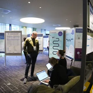 Person ser på konferanseplakat