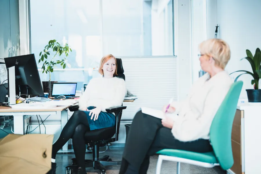 En kvinne som sitter ved siden av en annen kvinne