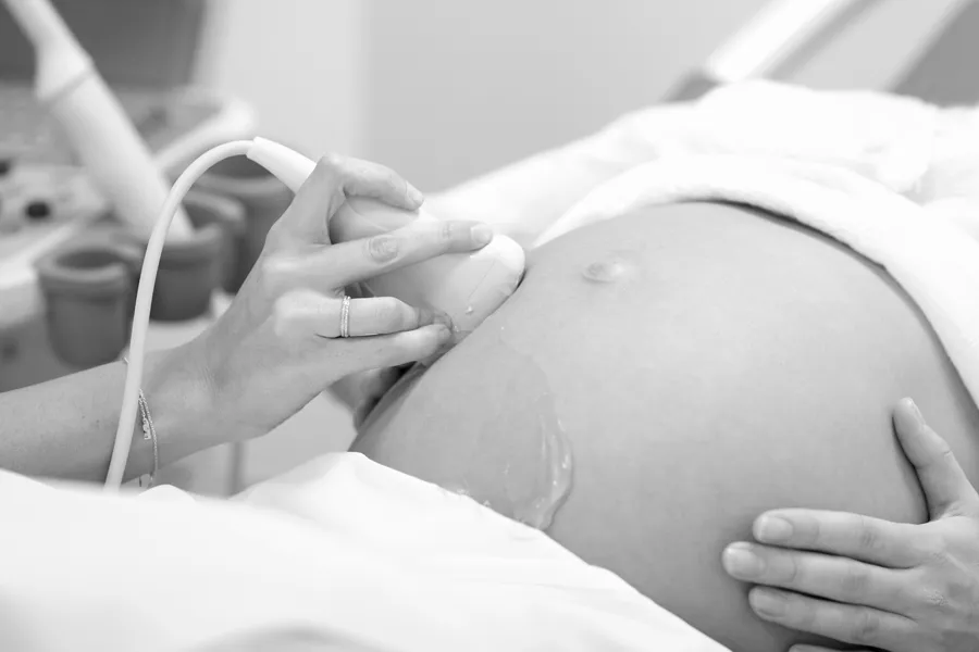 En lege som tar seg av en gravid pasient