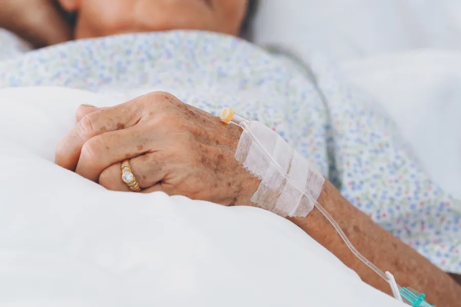 Nærbilde av hånden til kvinne i sykehusseng