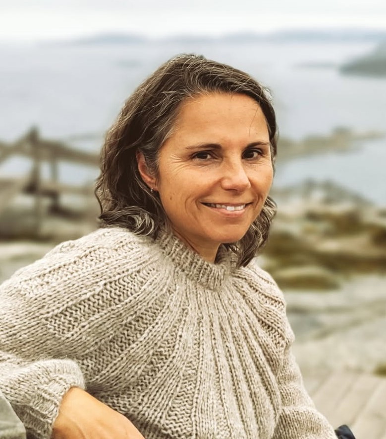 En kvinne som smiler til kameraet