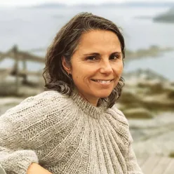 En kvinne som smiler til kameraet