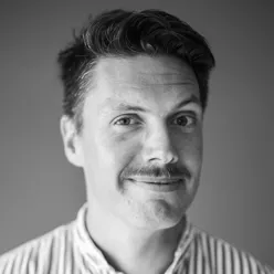 En mann som smiler til kameraet