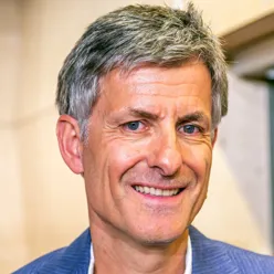 En mann som smiler til kameraet