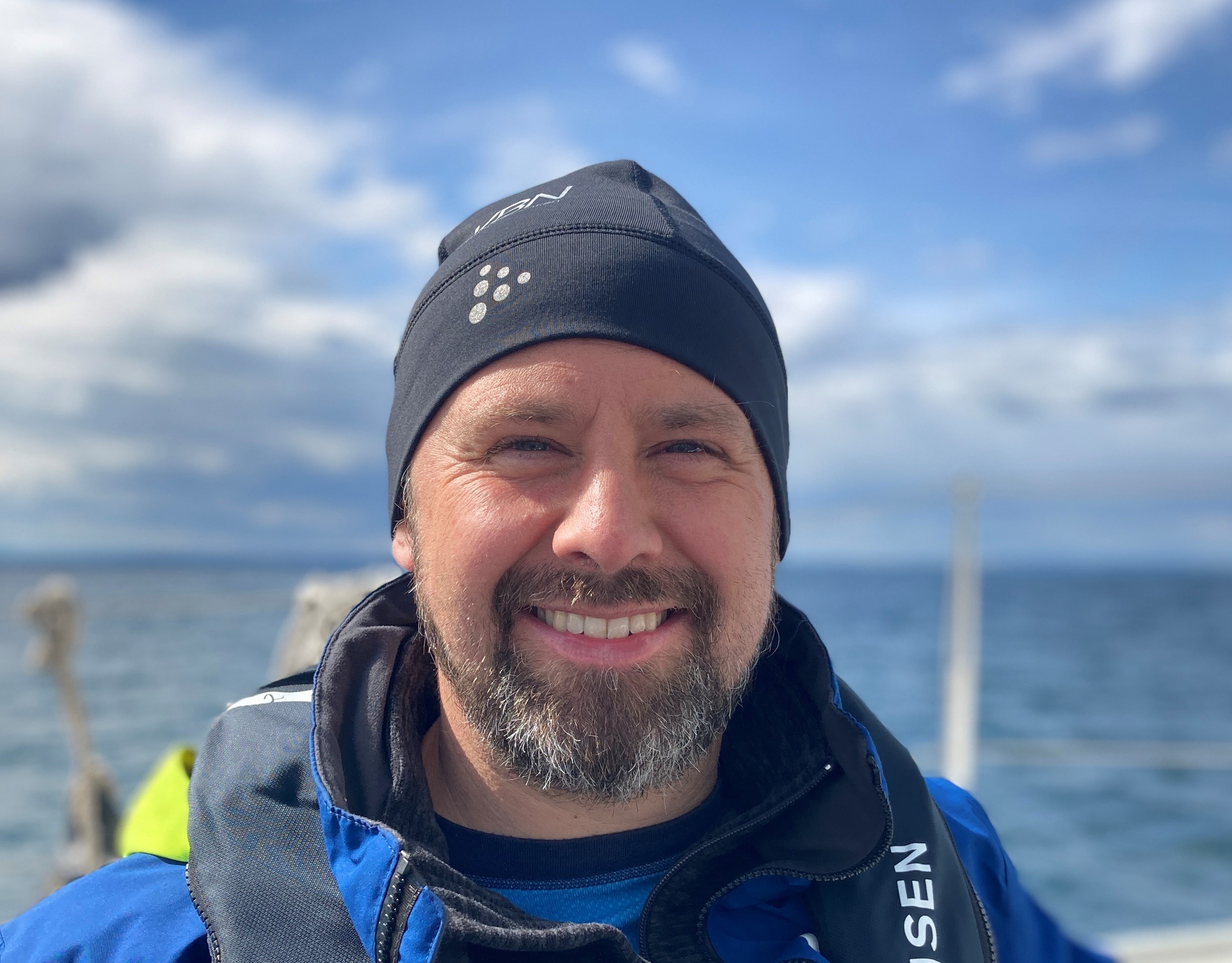 En mann som smiler til kameraet