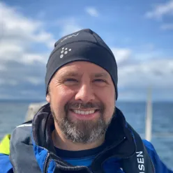 En mann som smiler til kameraet