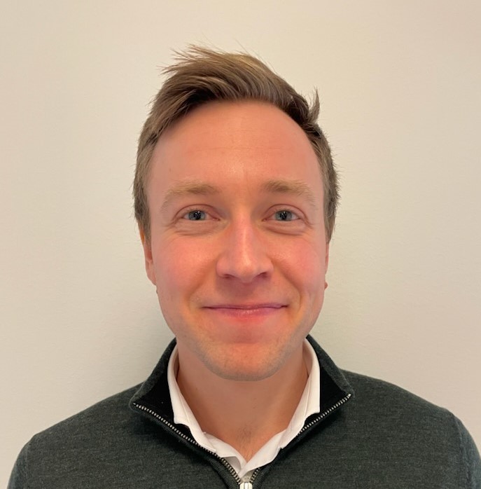 En mann som smiler til kameraet