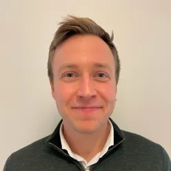 En mann som smiler til kameraet