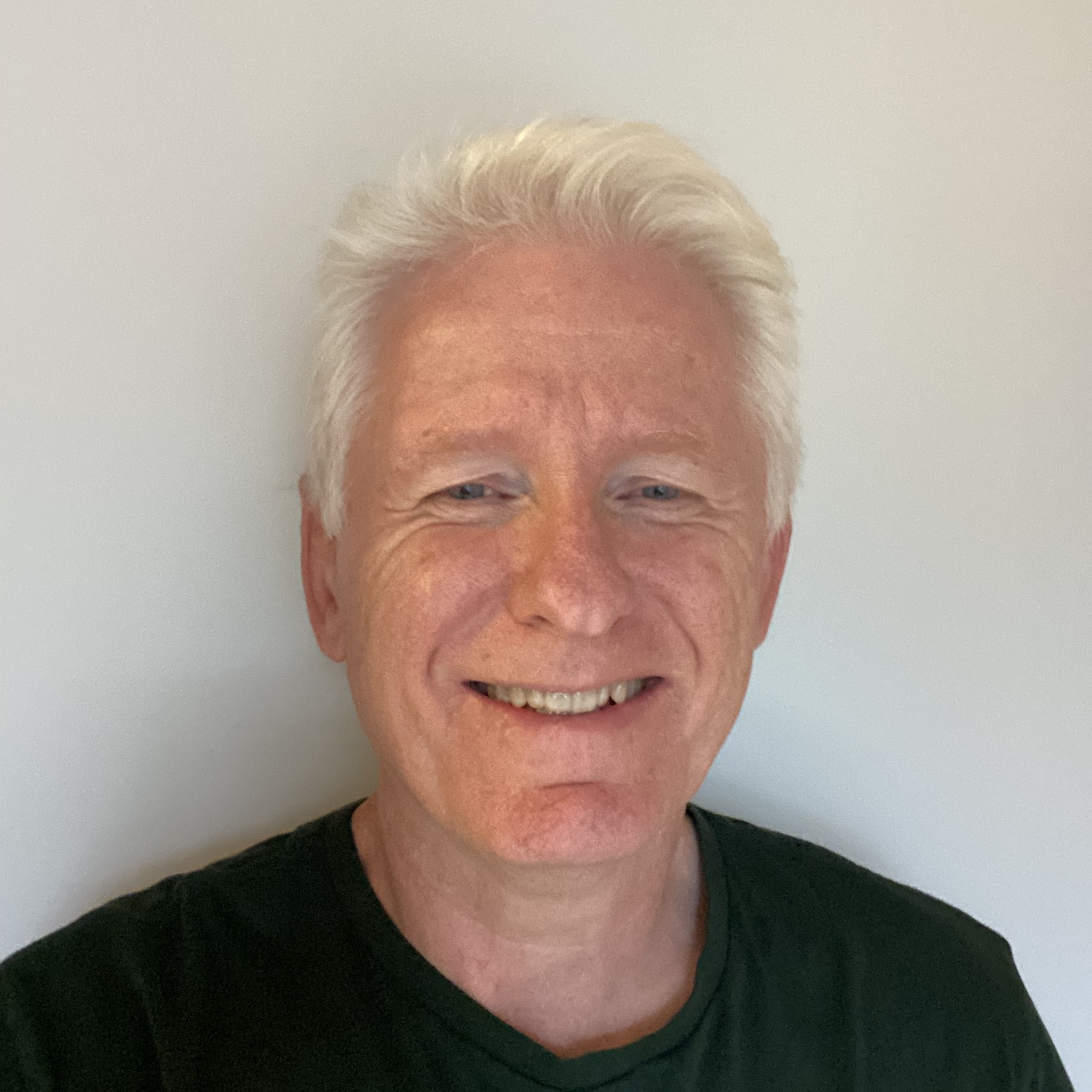 En mann som smiler til kameraet