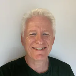 En mann som smiler til kameraet